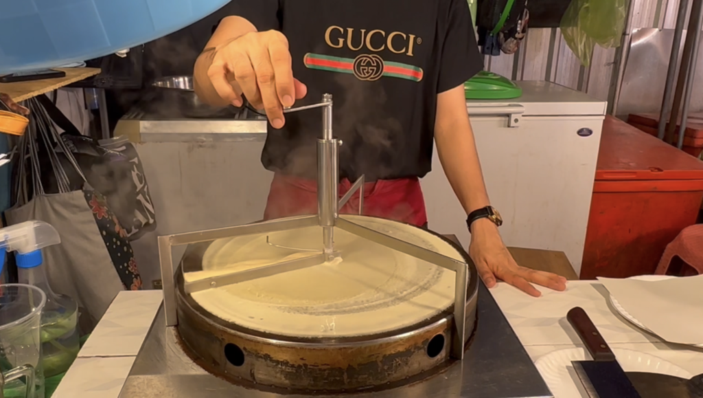 Spreading roti batter with crepe spreader tool